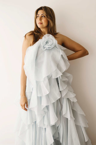A lady wearing the Mama Rentals Aje Pandorea Layered Maxi Dress - Silver Blue in a studio.