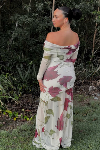 Pregnant woman showing the back design of the Mama Rentals By Nicola Belle Maxi Dress in Bordeaux Floral  standing outdoors with greenery in the background