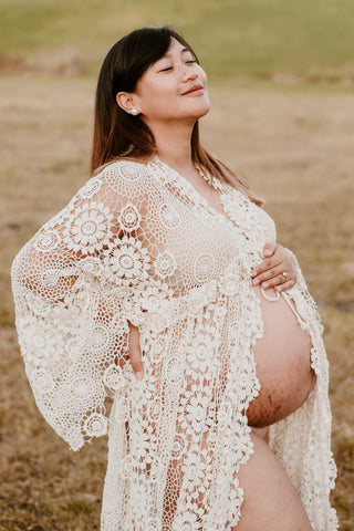 Pregnant woman wearing the Mama Rentals Elvira Crochet Robe at her maternity shoot.