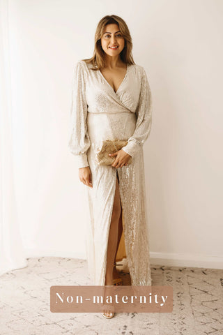 A woman wearing the Mama Rentals Jasmine Sequin Gown - Champagne holding the Olga Berg Quinn Woven Gold Clutch in a studio.