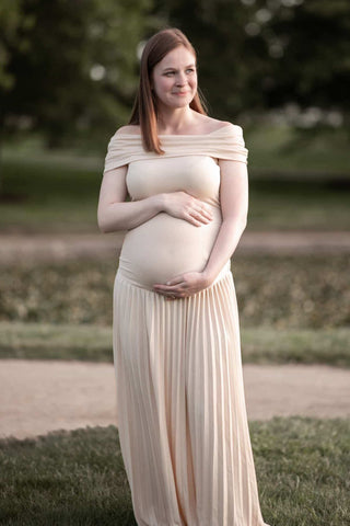 A pregnant lady wearing the Lioness Field of Dreams Maxi Dress - Oatmeal at her maternity photoshoot.